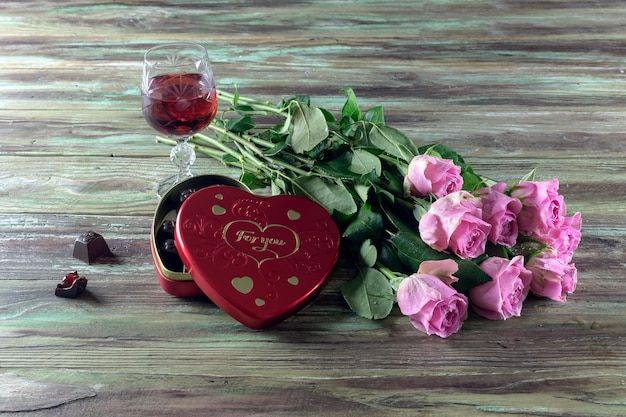 Still Life by Valentines Day Un ramo de rosas rosadas una copa de vino y una caja de dulces en forma de corazón