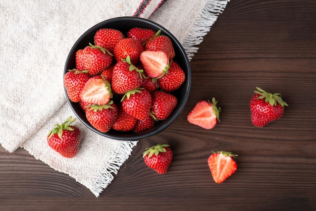 Still life foto de fresas maduras frescas en tazón negro Foto de estudio