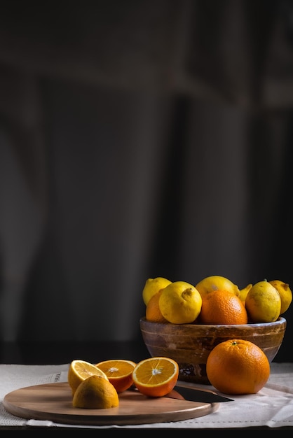 Stilleben auf dunklem Hintergrund Orangen und Zitronen auf Holztisch