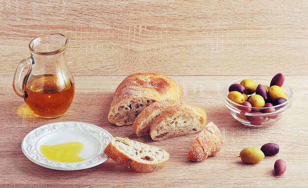 Stilleben mit geschnittenem Brot und Ciabatta, Oliven und Olivenöl