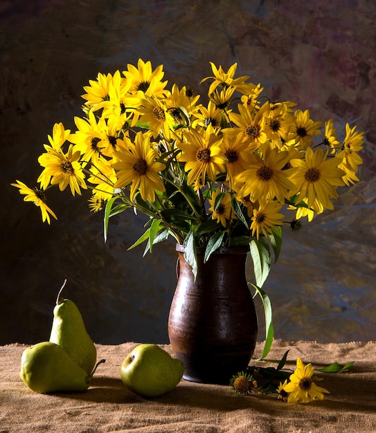 Stilleben mit leuchtend gelben Blumen (Rudbeckia) in brauner Vase und Birnen