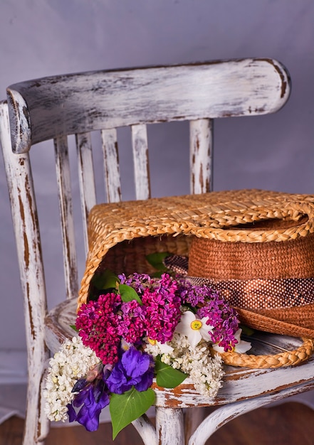 Stilleben mit lila Blumen und Hut auf vintaje cher