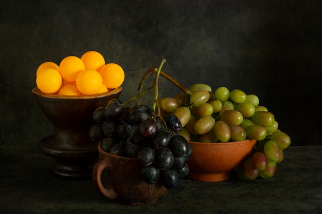 Stilleben mit reifen Weintrauben und Orangenkugeln