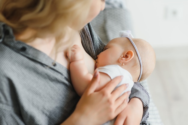 Stillkonzept. Junge Mutter stillt ihr neugeborenes Baby zu Hause, Nahaufnahme