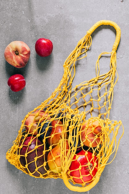 Foto stillleben der gelben biologisch abbaubaren einkaufstasche mit rohen früchten