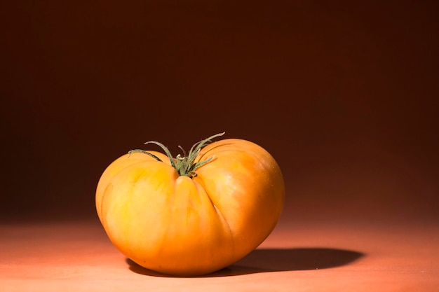 Stillleben einer Sorte Raf Tomate oder Honig mit dunklem Hintergrund und roter Oberfläche