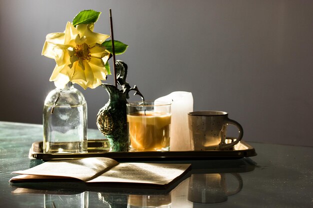 Foto stillleben kaffeetasse blühende gelbe rosenknospe rosenblüte in vase im frühling duftstäbchen rauch