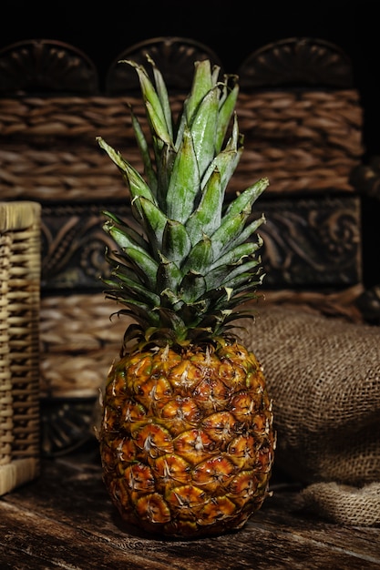 Stillleben mit Ananas auf hölzerner rustikaler Tabelle.