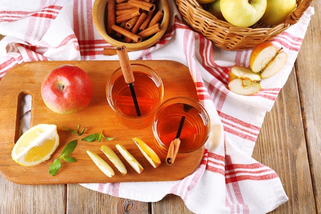 Stillleben mit Apfelwein und frischen Äpfeln auf Holztisch