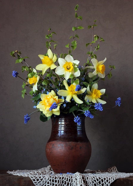 Stillleben mit einem Bouquet von Narzissen und anderen Frühlingsblumen auf dunkel