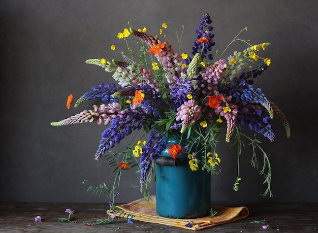 Stillleben mit einem Sommerstrauß aus Lupinen und Butterblumen