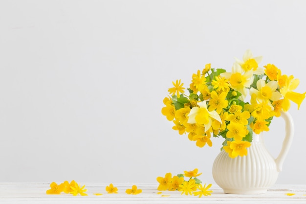 Stillleben mit gelben Frühlingsblumen im Krug