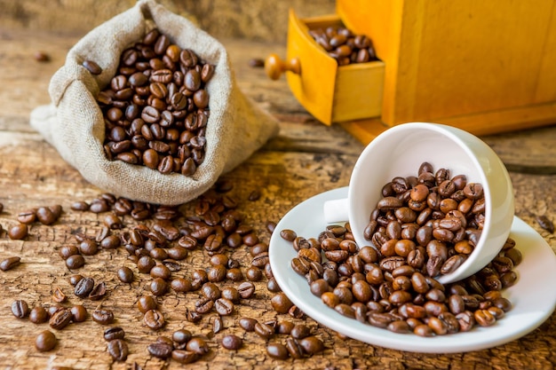 Stillleben mit Kaffeebohnen und alter Kaffeemühle auf Holzhintergrund