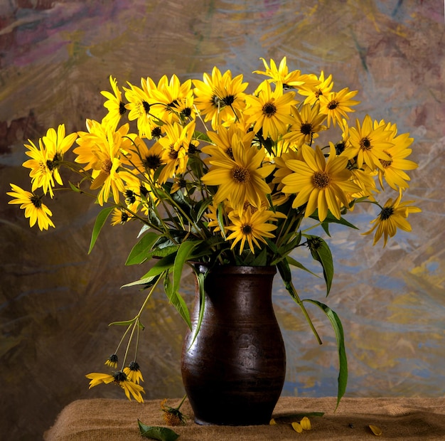 Stillleben mit leuchtend gelben Blumen (Rudbeckia) in brauner Vase