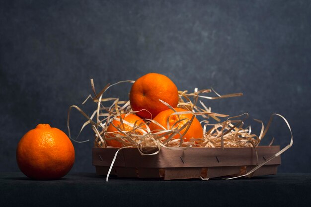 Foto stillleben mit reifen mandarinen in einer schachtel auf dem tisch