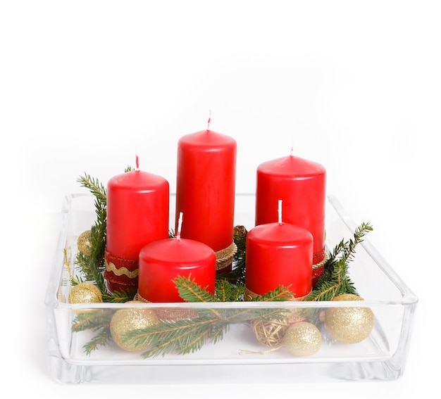 Stillleben mit roten Kerzen, goldenen Kugeln und Bändern, Tannenzweigen in Glaswaren auf weißem Hintergrund, Weihnachtskerzen, Adventskerzen