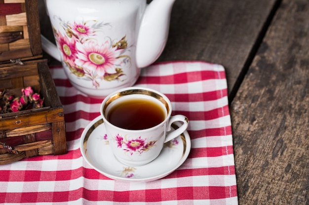 Stillleben mit Teeschale und Tischdecke auf Holztisch