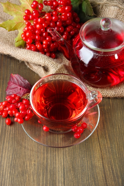 Stillleben mit Viburnum-Tee auf Sackleinenserviette, auf Holztisch