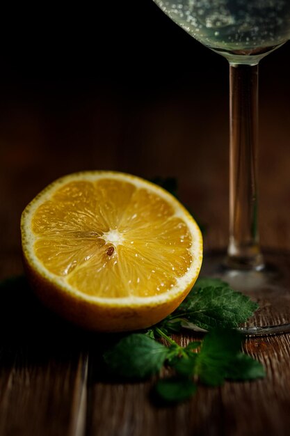 Stillleben mit Zitronencocktailglas und Minzblatt auf einem Holztisch