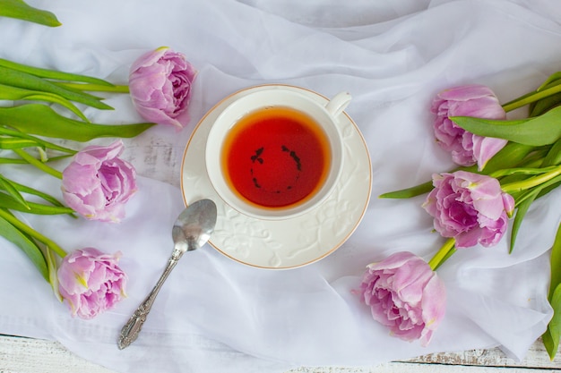 Stillleben Teebecher und Strauß Tulpen weißer Stoff