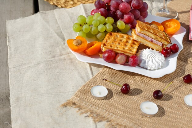 Stillleben und Essensfoto Ein Teller mit Früchten und Waffeln steht auf einer Sackleinen