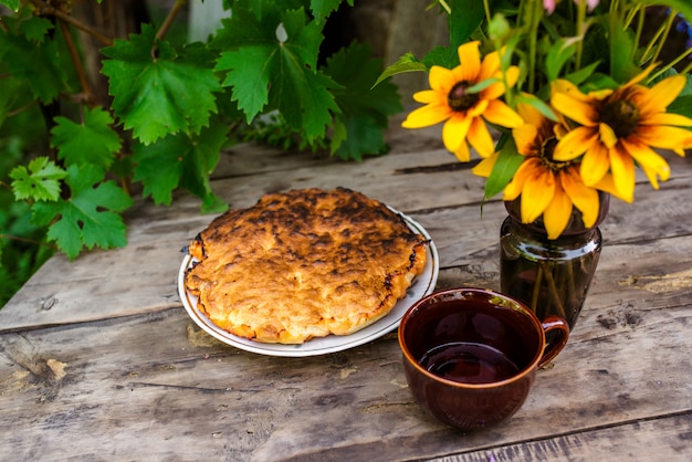 Stillleben von Blumen und Backen mit Beeren auf einem Holztisch.