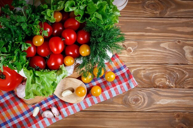 Stillleben von frischen Tomaten, Knoblauch und Petersilie auf Holzbrettern.