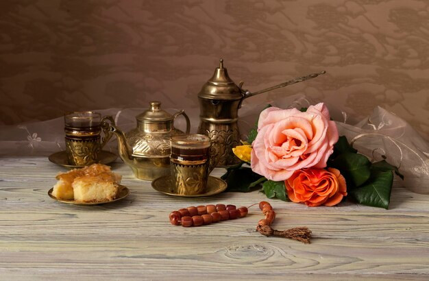 Stilllife con rosas de primavera y servicio de café en un primer plano de la mesa de madera