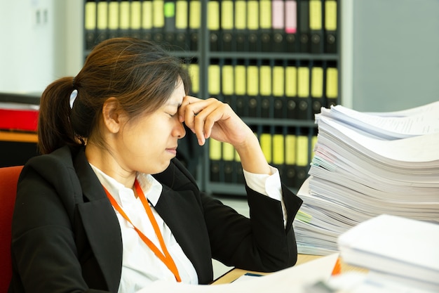 Stillstehende Hände der Geschäftsfrau auf Kopf mit Augen schließen am Arbeitsschreibtisch im Büro.