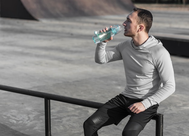 Foto stillstehendes und trinkwasser des jungen mannes