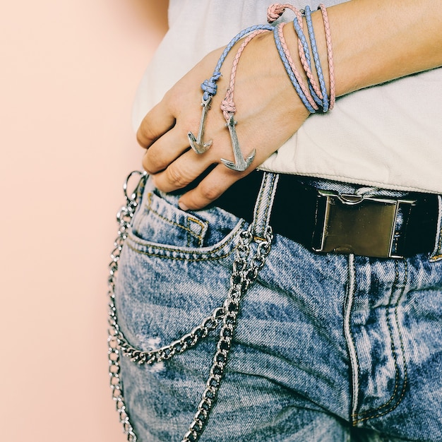 Stilvolle Accessoires. Armbänder Anker und Ketten an Jeans.