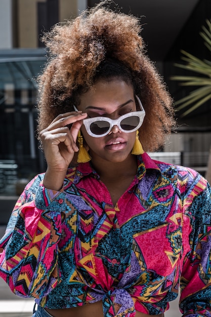 Stilvolle Afroamerikanerin in der Sonnenbrille auf der Straße