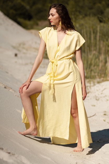 Stilvolle, attraktive, schlanke, lächelnde Frau am Strand im Sommerstil, Modetrend-Outfit, glücklich, Spaß zu haben