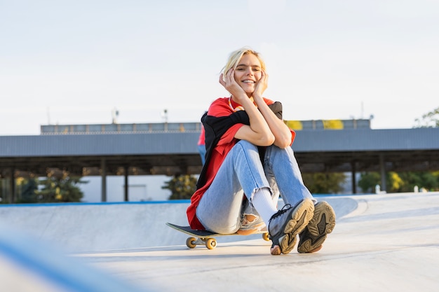 Stilvolle coole Teenager-Skateboarderin im Skatepark
