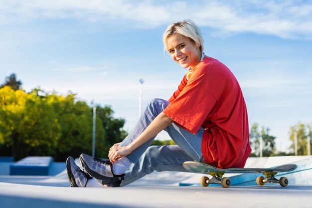 Stilvolle coole Teenager-Skateboarderin im Skatepark