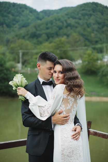 Stilvolle europäische Hochzeit bei Sonnenuntergang. Glückliches Paar im Wald in der Natur.