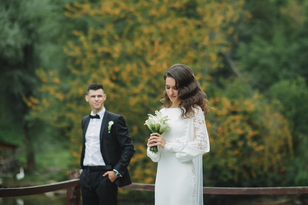 Stilvolle europäische Hochzeit bei Sonnenuntergang. Glückliches Paar im Wald in der Natur.