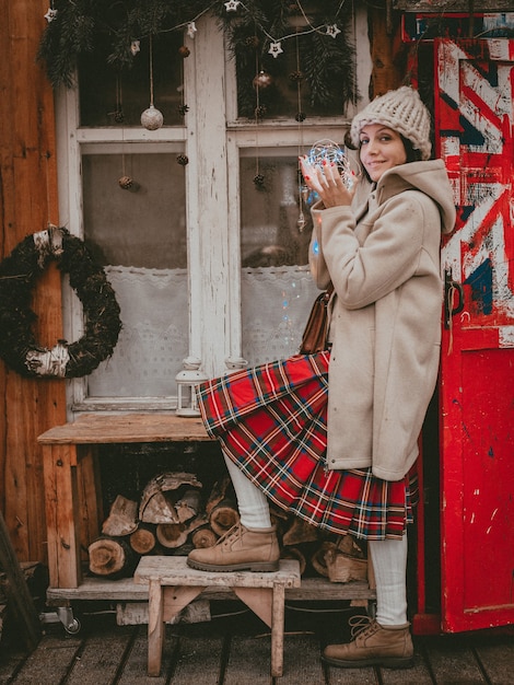 Stilvolle Frau dekorierte Neujahrsferien Terrasse modernen Öko rustikalen Minimal-Stil Britische Flagge Skandinavischen Stil handgemachte Weihnachten. Innendekoration Ideen billiges Holzfenster, natürliches Material