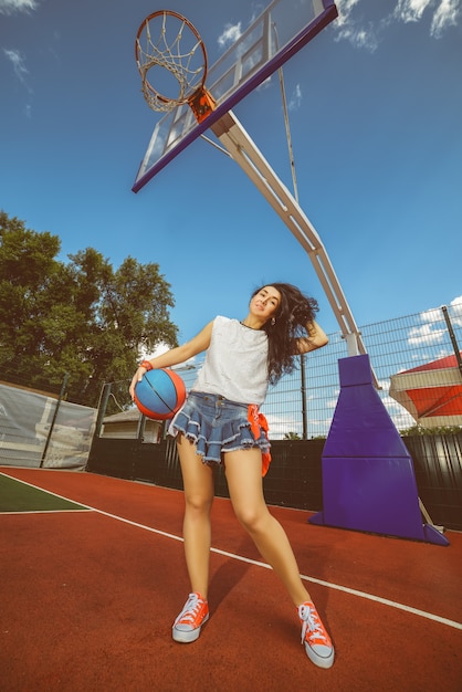 Stilvolle Frau, die am Basketballplatz aufwirft