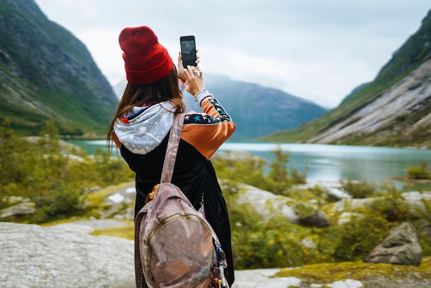 Stilvolle Frau fotografiert am Telefon im reisenden Lifestyle-Abenteuerkonzept Reisen