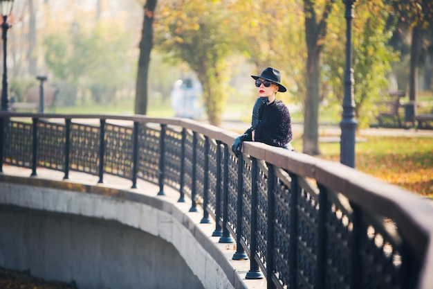 Stilvolle Frau im Herbstpark