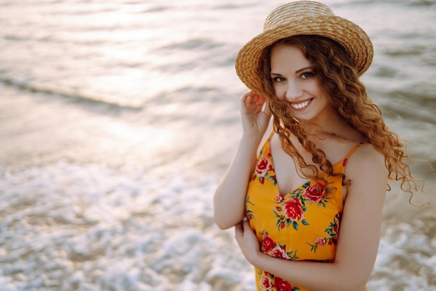 Stilvolle Frau in elegantem Kleid posiert am Meer Sommerzeit Reisewochenende entspannen