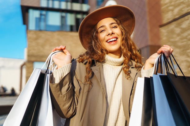 Stilvolle Frau mit Einkaufstaschen geht durch die Straßen der Stadt Konsumismus Einkauf Lifestyle Konzept
