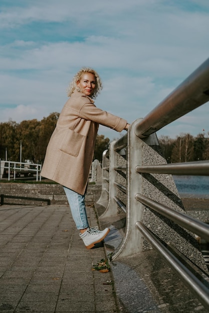 Stilvolle hübsche junge Frau in der Herbstmode, die in die Stadt spaziert