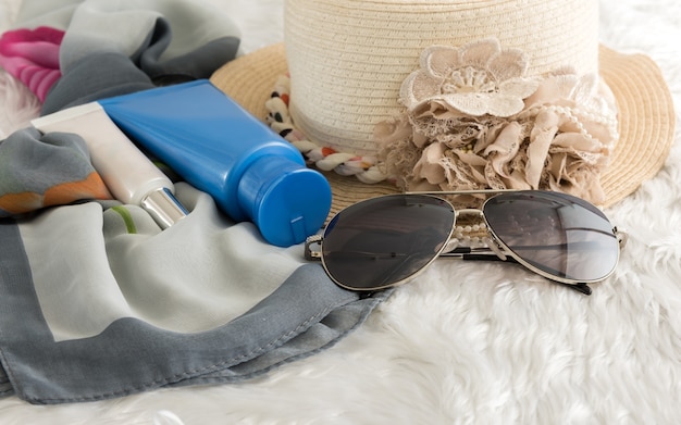 stilvolle Hut Frau Sonnenbrille und Tablet Mode Schal, Sonnencreme auf Wolle Hintergrund. Urlaub an