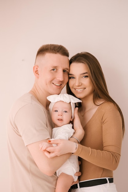 Stilvolle junge Familie fotografiert mit einem kleinen schönen Baby Die Familie drückt Liebe und Ehrfurcht zueinander aus Familien- und Erziehungskonzept