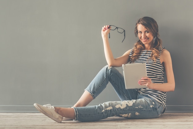 Stilvolle junge Frau benutzt eine digitale Tablette