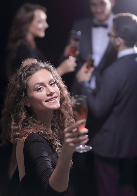 Stilvolle junge Frau, die ein Glas Champagner anhebt