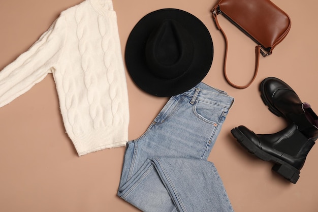 Stilvolle Kleidung, Schuhe und Accessoires auf beige Hintergrund