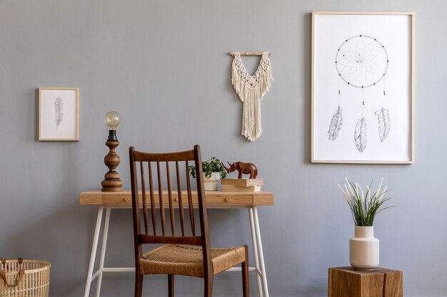 Stilvolle Komposition aus kreativem, geräumigem Worspace-Interieur mit Mock-up-Posterrahmen, Tisch, Stuhl, Pflanzen, Teppich und Accessoires. Graue Wände und Parkettboden. Boho-Stil. Vorlage